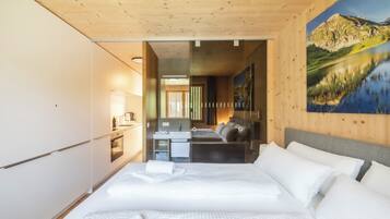 Ein Schlafzimmer mit einem großen Bett, einer kleinen Küchenzeile und einem Badezimmer.