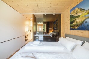 Ein Schlafzimmer mit einem großen Bett, einer kleinen Küchenzeile und einem Badezimmer.