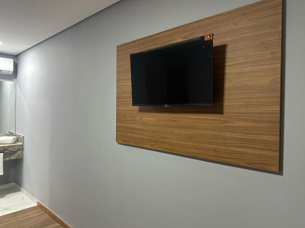 Ein modernes Badezimmer mit einer Holzvertäfelung, einem integrierten Waschbecken und einem Handtuchhalter.