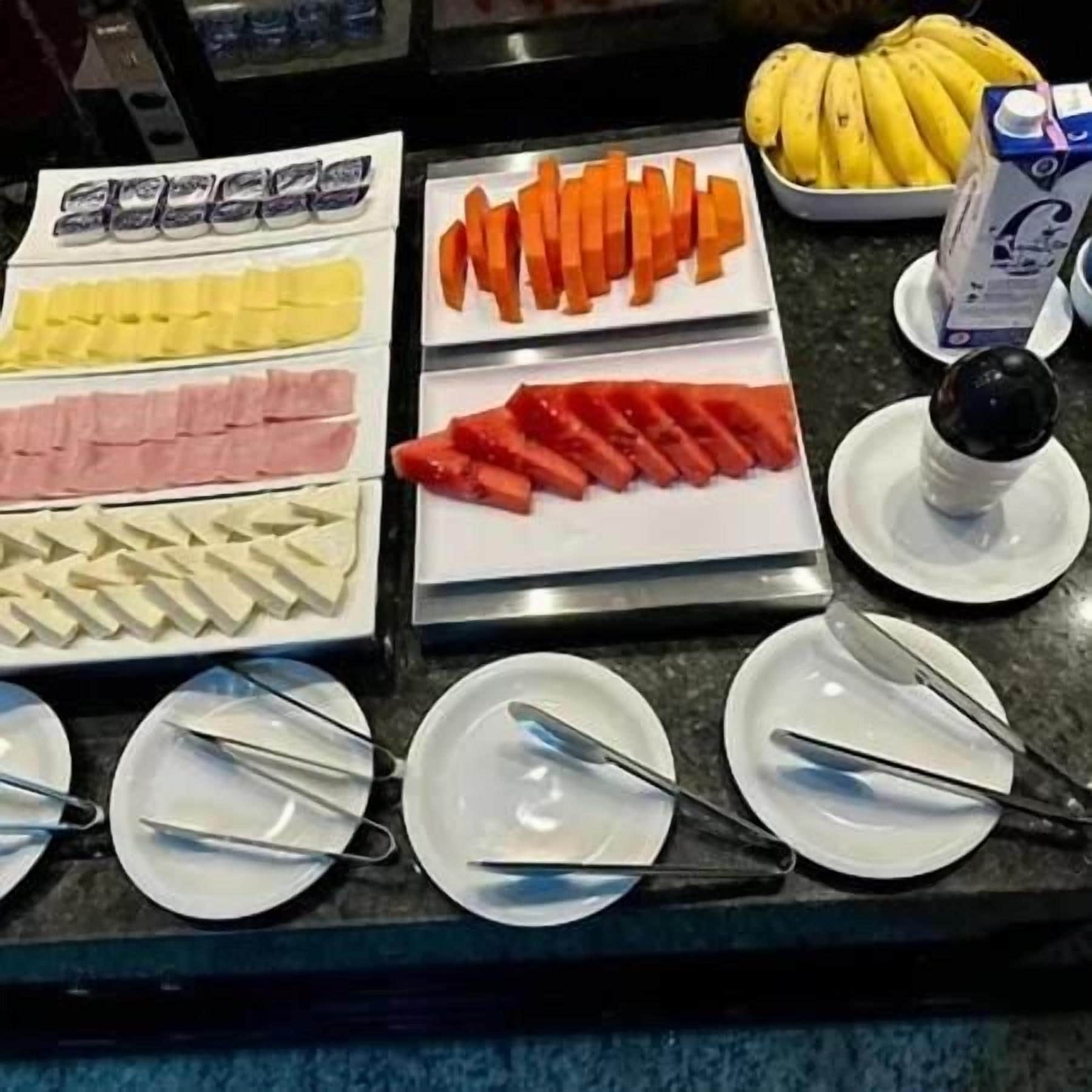Buffet-pöytä, jossa on tarjolla monenlaista ruokaa ja ruokailuvälineitä.