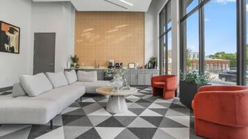 A modern interior with a sectional sofa, a round coffee table, and red chairs.