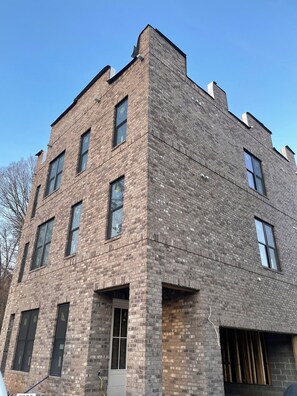 A multi-story brick building with large windows and a flat roof. - NEW Cowgirl Brownstone near UT - 3 king suites, rooftop deck w Hottub (Knoxville)