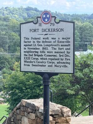 Historisch informatiebord voor Fort Dickerson, met een achtergrond van groen en heuvels.