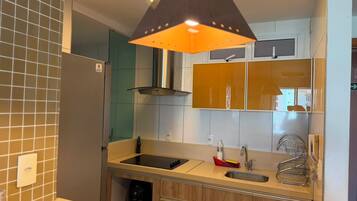 Een moderne keuken met een ingebouwde oven, een spoelbak en een RVS afzuigkap.
