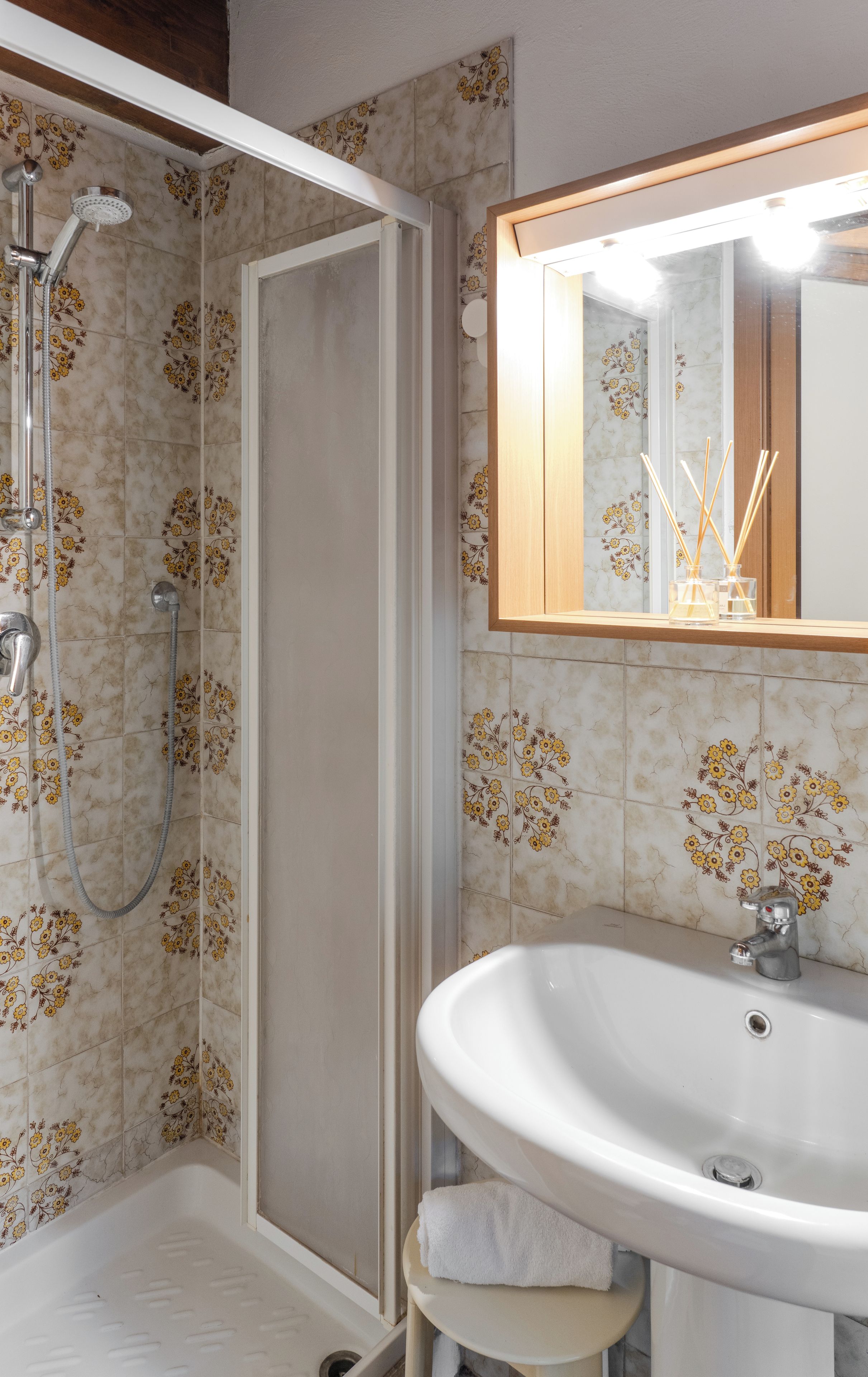 Ein Badezimmer mit Dusche, Waschbecken und Spiegel.