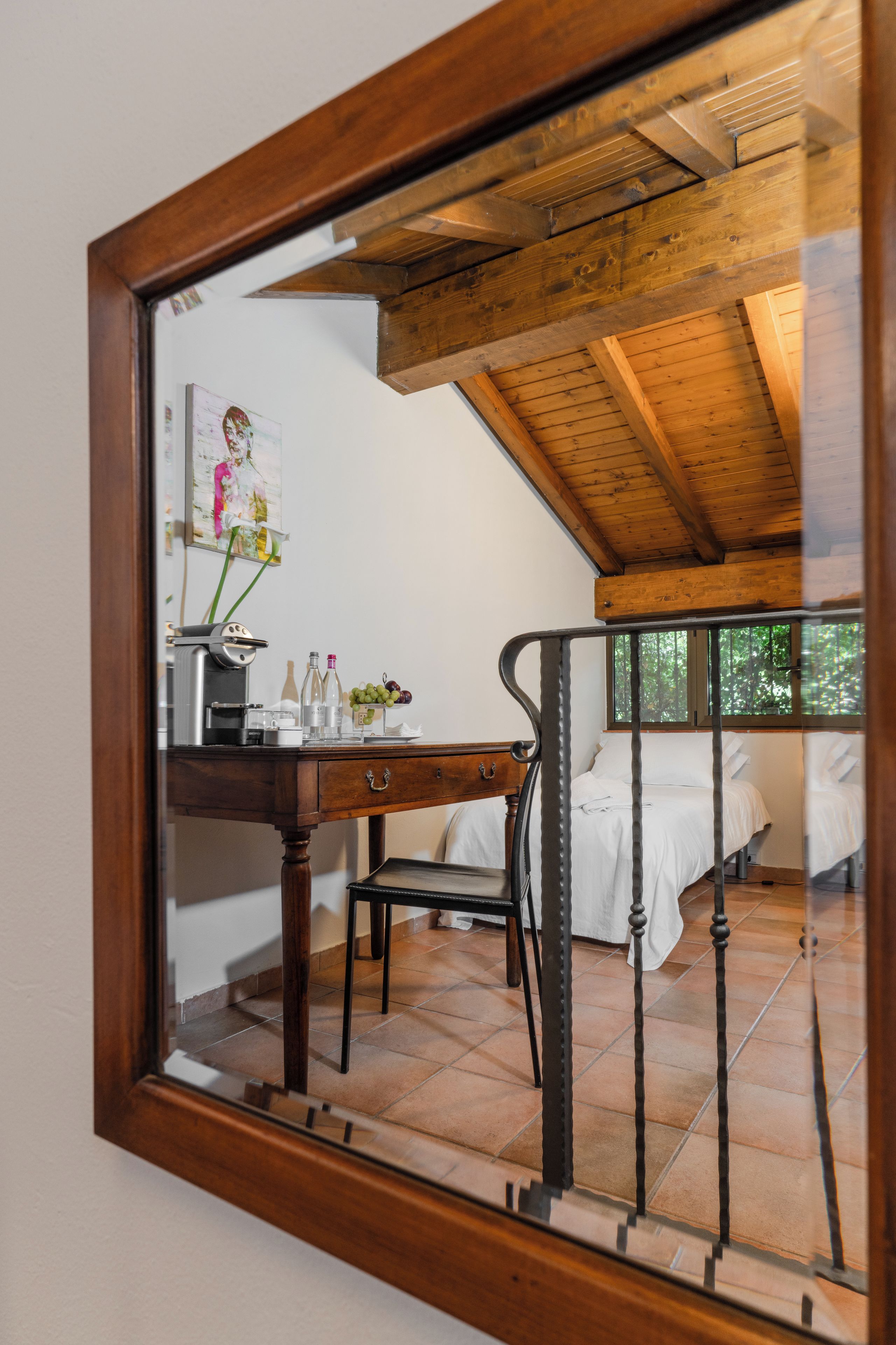 Une chambre avec un plafond en bois, un lit avec une literie blanche et un bureau avec une chaise.