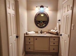 Une salle de bain avec un meuble-lavabo, un miroir et un porte-serviettes.