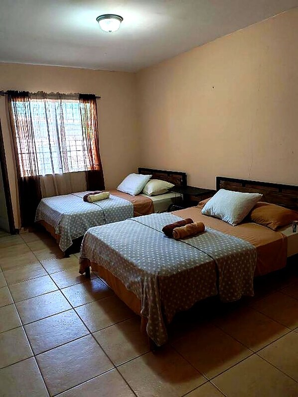 A room with two beds, each with a pillow and a blanket. - D Monte Alto (ALTO BOQUETE)