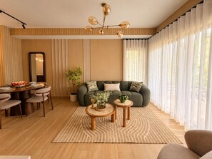 A modern living room with a sofa, coffee table, and dining area. - Lovely 2-bedroom apartment with AC in vibrant Punta Cana (Punta Cana)