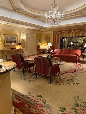 A luxurious room with a red sofa, a chandelier, and a floral carpet. - Las Vegas New Year's Luxury Penthouse 2 Bedroom Suite with Views of the Strip (Las Vegas)