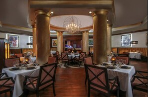 A restaurant with round tables, chairs, and a chandelier. - Las Vegas New Year's Luxury Penthouse 2 Bedroom Suite with Views of the Strip (Las Vegas)