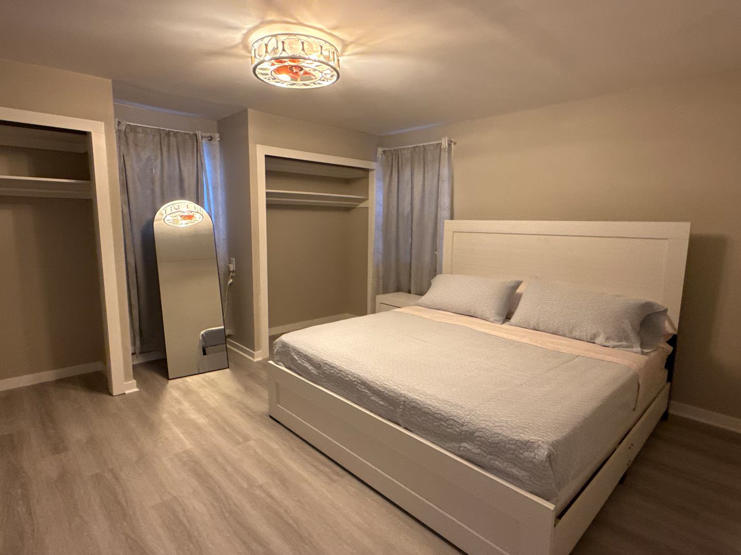 Un dormitorio con cama, armario y espejo.
