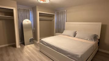 Un dormitorio con cama, armario y espejo.