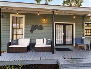 A porch with two wicker sofas, a small table, and a grill. - Downtown Secluded Cottage #4 (Pensacola)