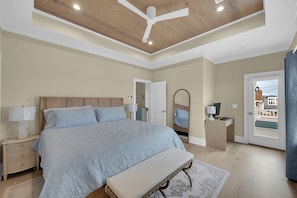 A bedroom with a large bed, bedside lamps, a ceiling fan, a mirror, and a view of the outside. - Lavallette Beach House 4BR/3BA - Perfect for Fall Getaways! - Sleeps 10 - Unit B (Lavallette)