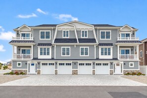 A two-story residential building with a symmetrical facade, multiple garage doors, and a central entrance. - Lavallette Beach House 4BR/3BA - Perfect for Fall Getaways! - Sleeps 10 - Unit B (Lavallette)