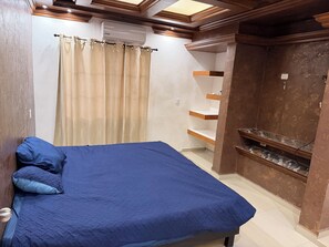 Un dormitorio con cama, armario y estantería empotrada.