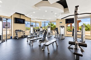 A gym with various exercise equipment, large windows, and a city view. - The Skyline Retreat @ Atlantic Station - Rooftop Pool & Gym (Atlanta)