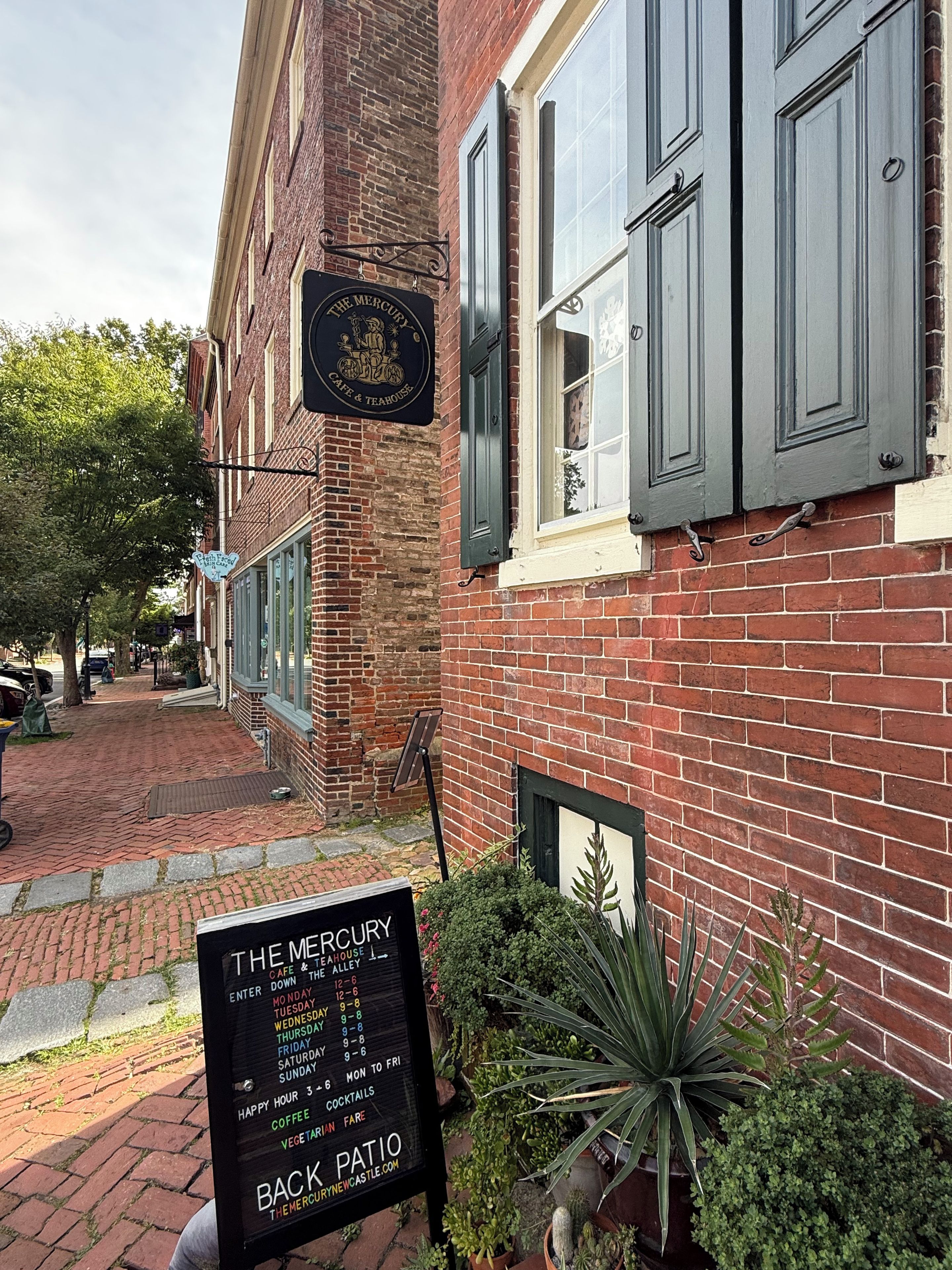 A brick building with a sign for The Mercury Cafe & Tea House.
