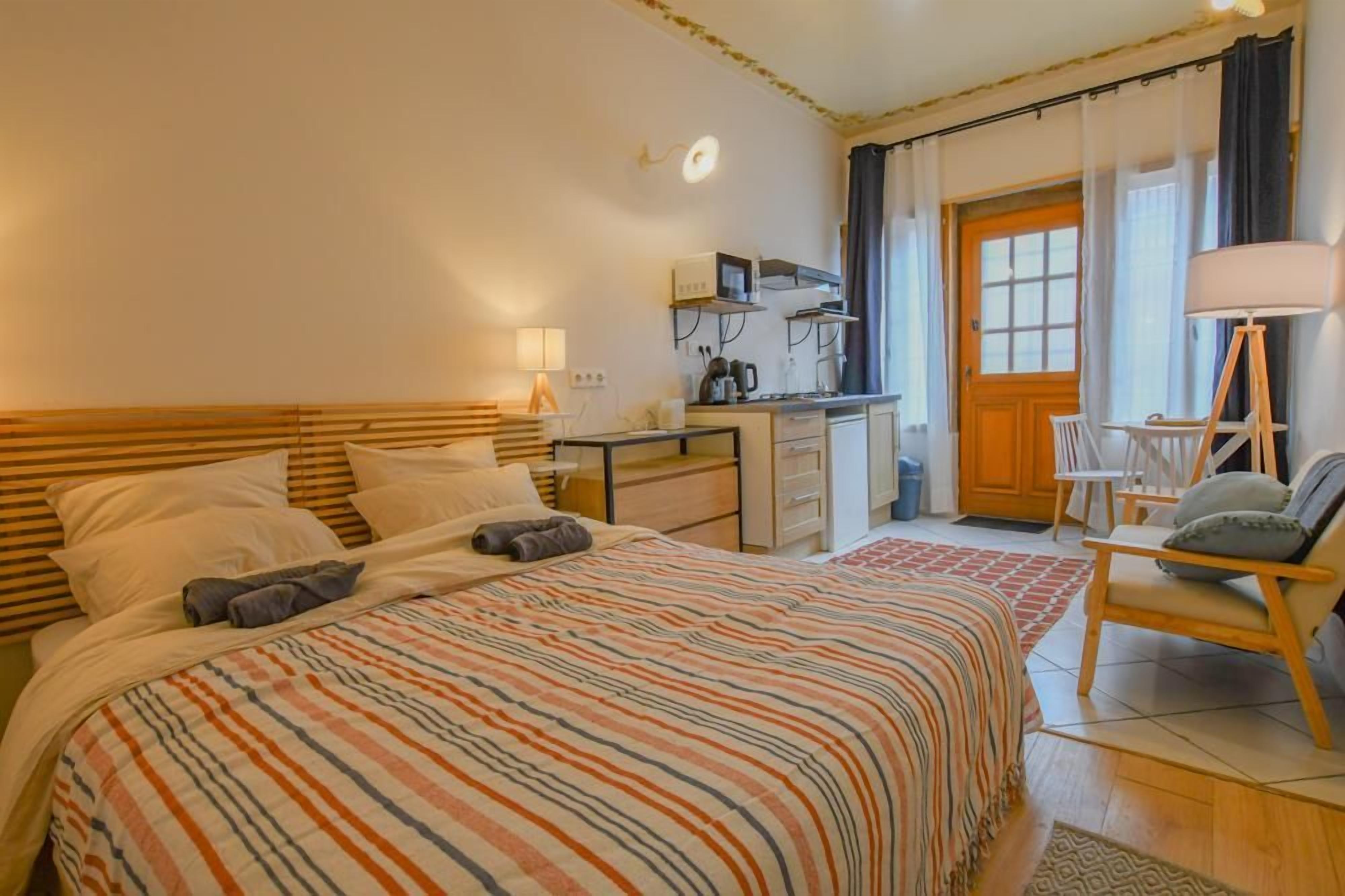 Ein Hotelzimmer mit Bett, Schreibtisch, Stuhl und Tür.