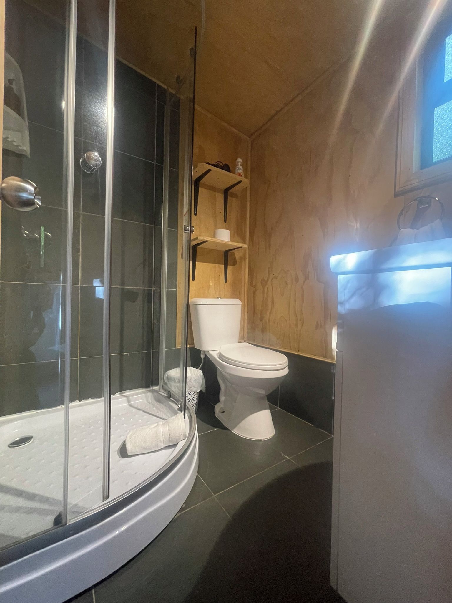 Un baño moderno con ducha envuelta en vidrio, inodoro y bañera.