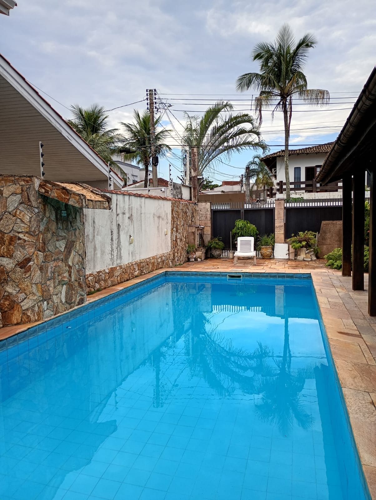A swimming pool with stone walls and a tiled deck.