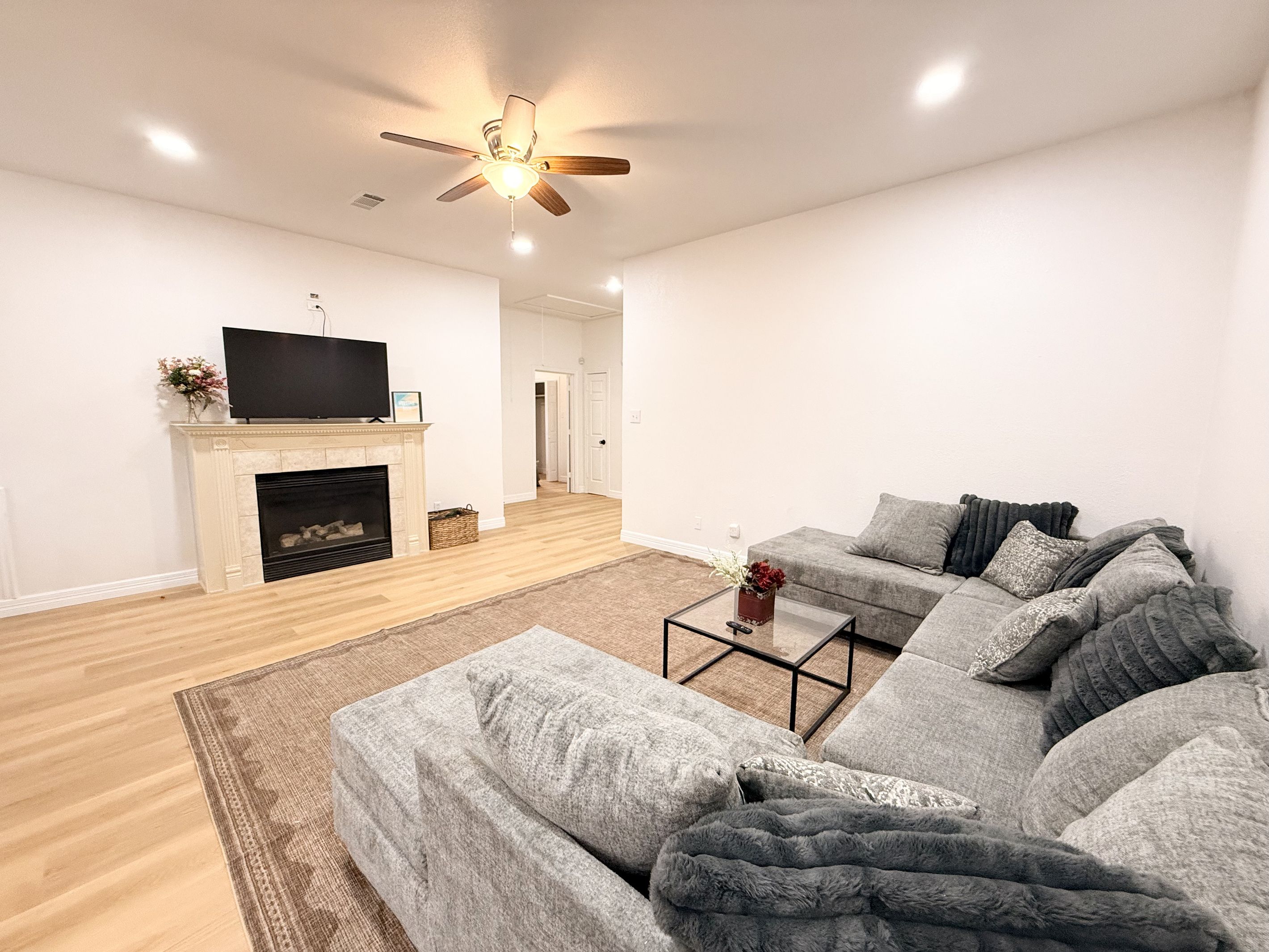Una sala de estar moderna con chimenea, un juego de sofás y una televisión.