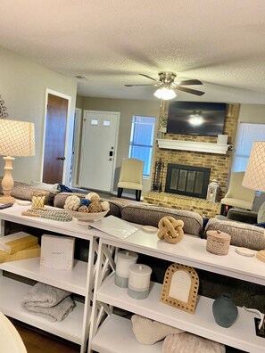 A living room with a fireplace, a sofa set, a television, and a ceiling fan. - Spacious 3-bedroom house in superb Abilene with AC (Abilene)