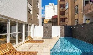 Ein Dachpool mit Liegestühlen und Blick auf die umliegenden Gebäude.