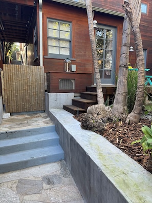 A wooden house with a concrete staircase, a wooden fence, and a tree. - Cozy Tuck-Under Studio in Silver Lake w/ Private Tropical Yard, Orange Trees (Los Angeles)