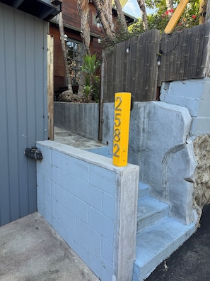 A concrete staircase leading to a door with a yellow sign displaying the number 2582. - Cozy Tuck-Under Studio in Silver Lake w/ Private Tropical Yard, Orange Trees (Los Angeles)