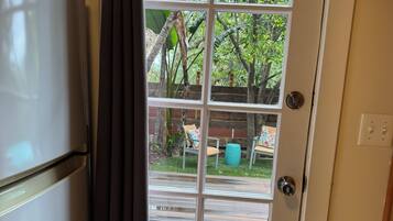 A kitchen with a refrigerator and a sliding glass door leading to an outdoor patio area.