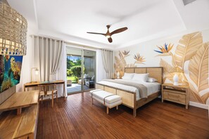 A bedroom with a bed, wooden desk, bench, ceiling fan, and a view of the outdoors. - Luxury Villa Designer updates HI Gem Kings (Waimea)