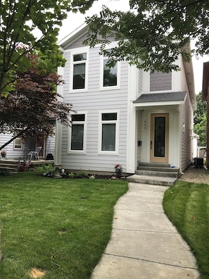 A two-story house with a front porch, a visible mailbox, and a well-maintained lawn.