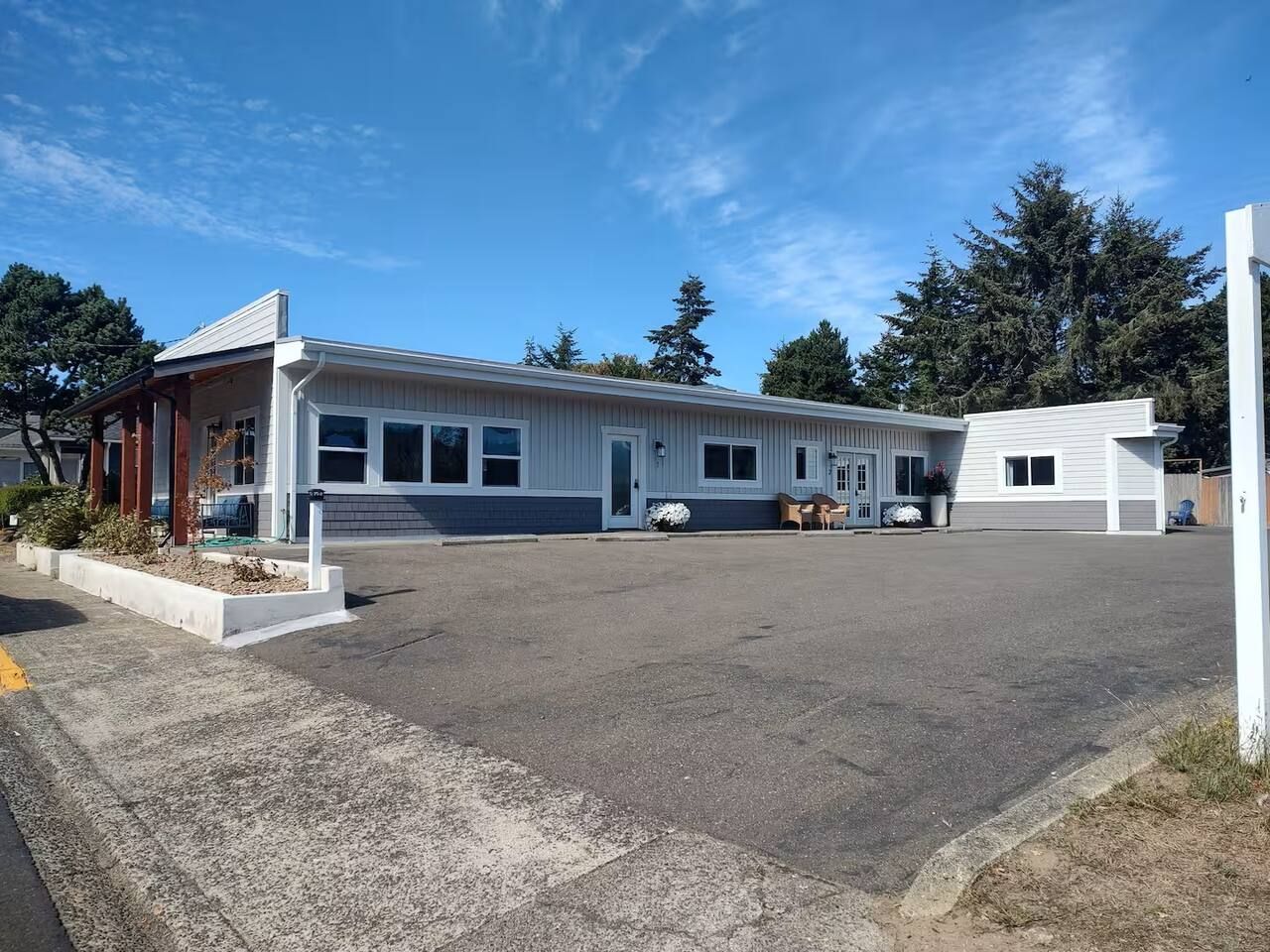 A single-story building with a garage, a covered porch, and a driveway.