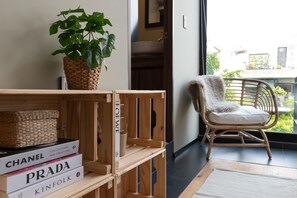 A room with a wooden shelf holding books, a wicker basket, and a potted plant. - Increible Terraza en la condesa (Ciudad de México)