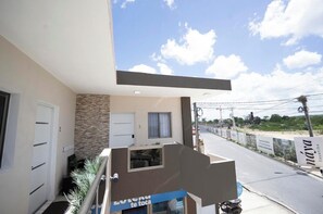 A hotel with a balcony overlooking a street, a stone facade, and a clear sky. - Elegant and Modern Apartment in Bayahíbe | Near the Beach (Bayahíbe)