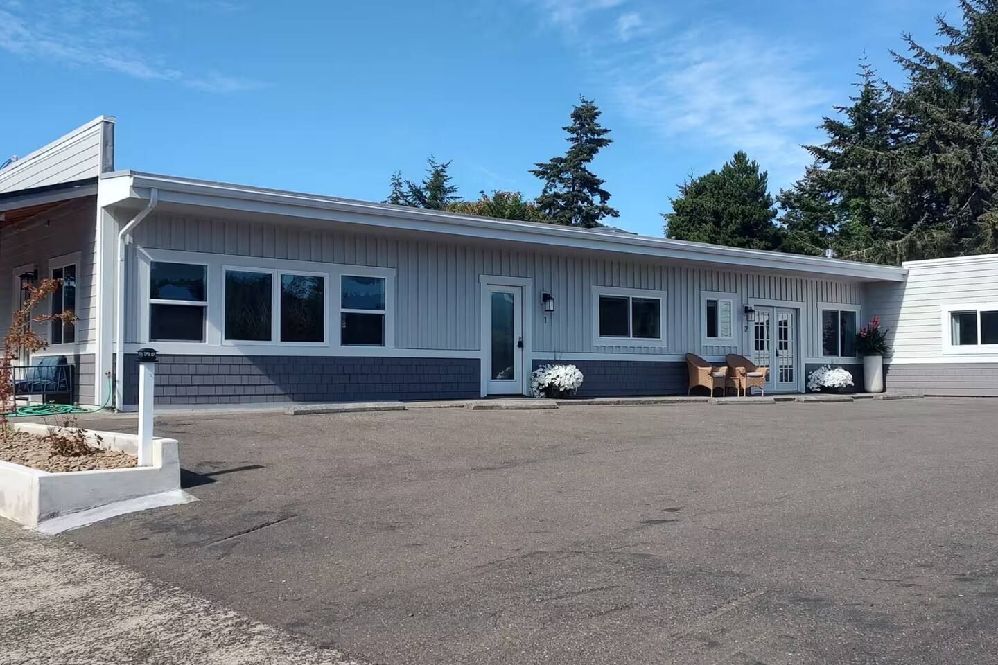 A single-story building with a flat roof, large windows, and a covered outdoor seating area.