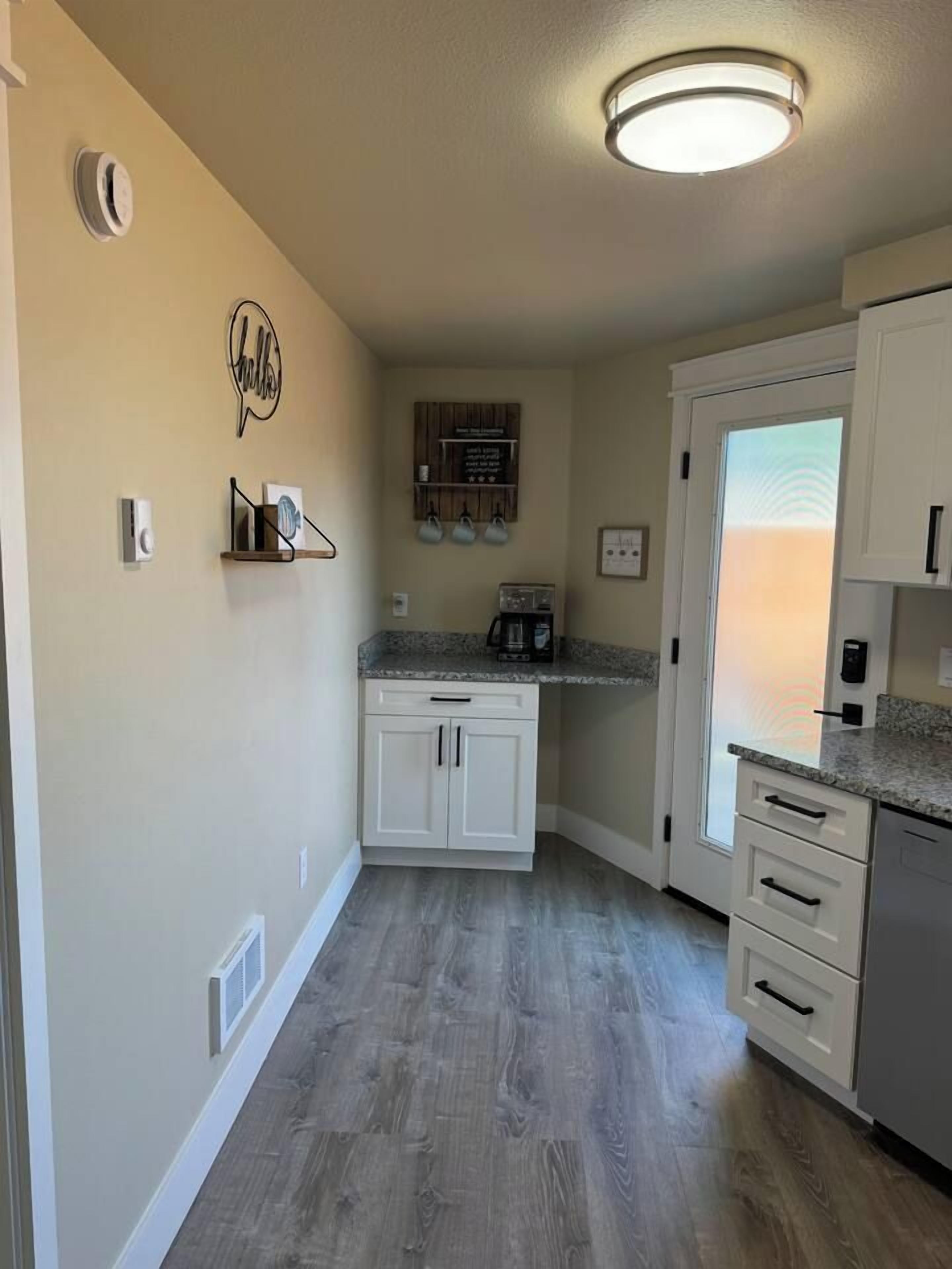A kitchen with white cabinets, a granite countertop, and a built-in oven.