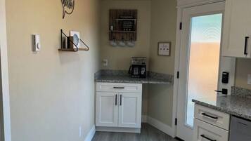 A kitchen with white cabinets, a granite countertop, and a built-in oven.