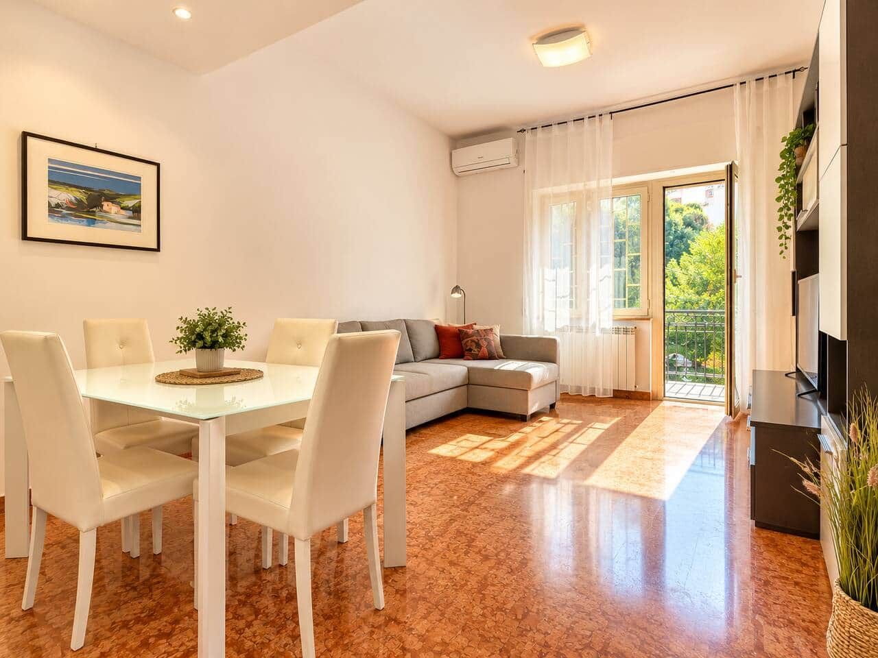 Ein modernes Wohnzimmer mit Essbereich, einer Couch und einem Fernseher.