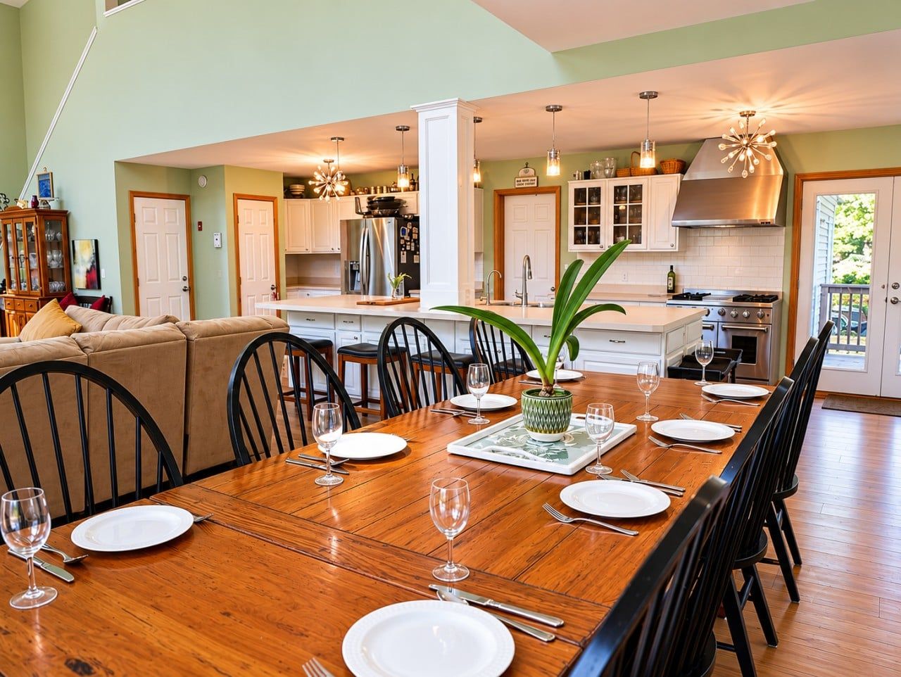A dining area with a wooden table set for six, surrounded by chairs.