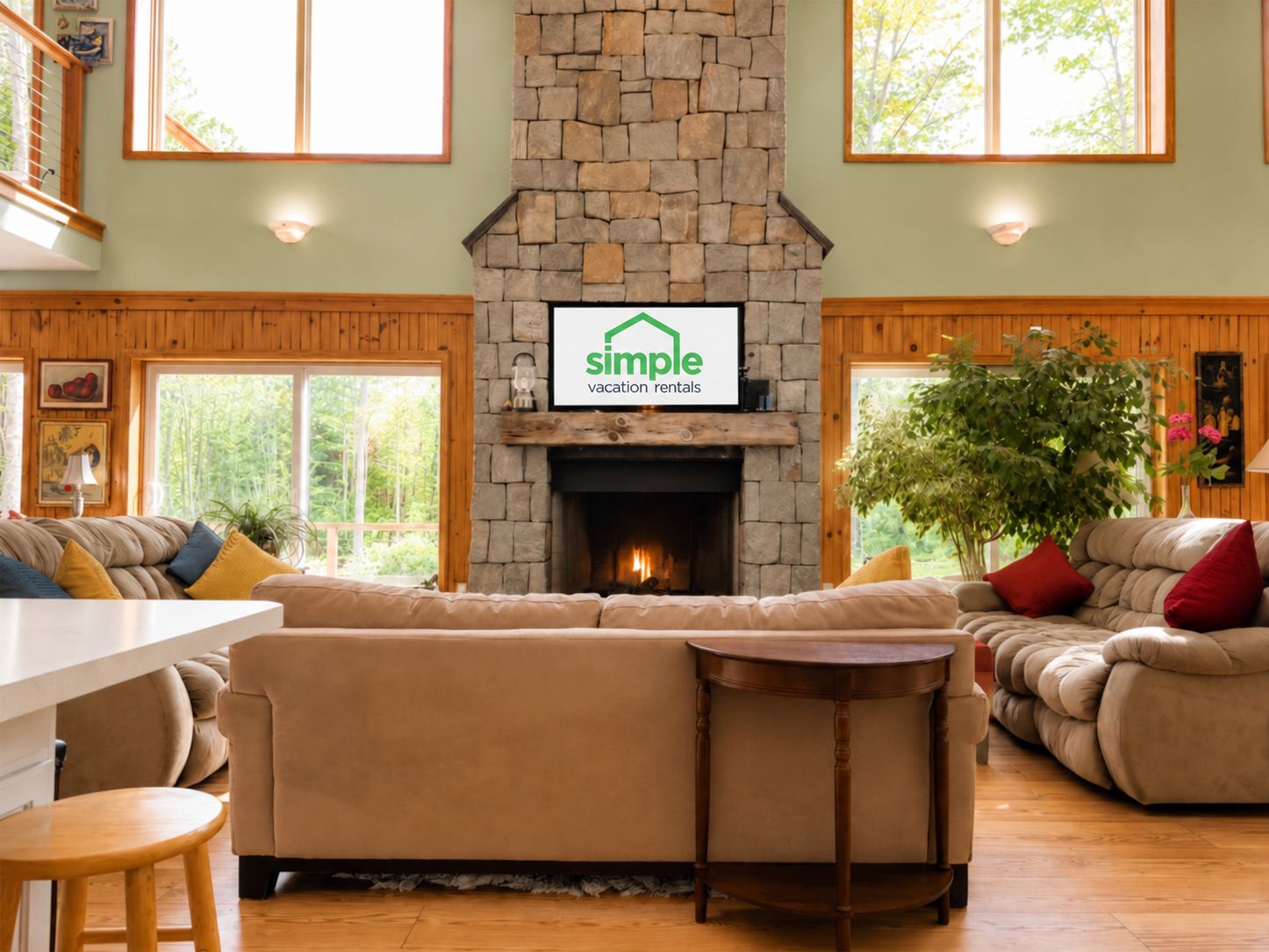 Bring the conversation back to the great room, where sofas face the stone fireplace beneath two levels of windows.