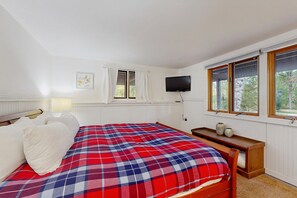 A bedroom with a bed, a television, a window, and a bedside table. - Riverview Retreat | beach, float, ski (Campton)
