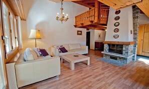 A living room with a sofa set, a coffee table, a fireplace, and a wooden staircase. - IN THE HEART OF ZERMATT,  JUST STEPS FROM THE VILLAGE’S MAIN STREET (Zermatt)