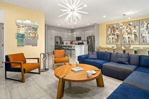 Ein modernes Wohnzimmer mit einer Couch, Sesseln und einem Couchtisch.
