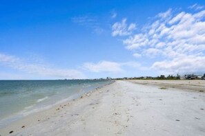 A beach with a clear sky and calm sea. - Sunset 304-Charming Beachfront Condo with Gulf Views (Fort Myers Beach)