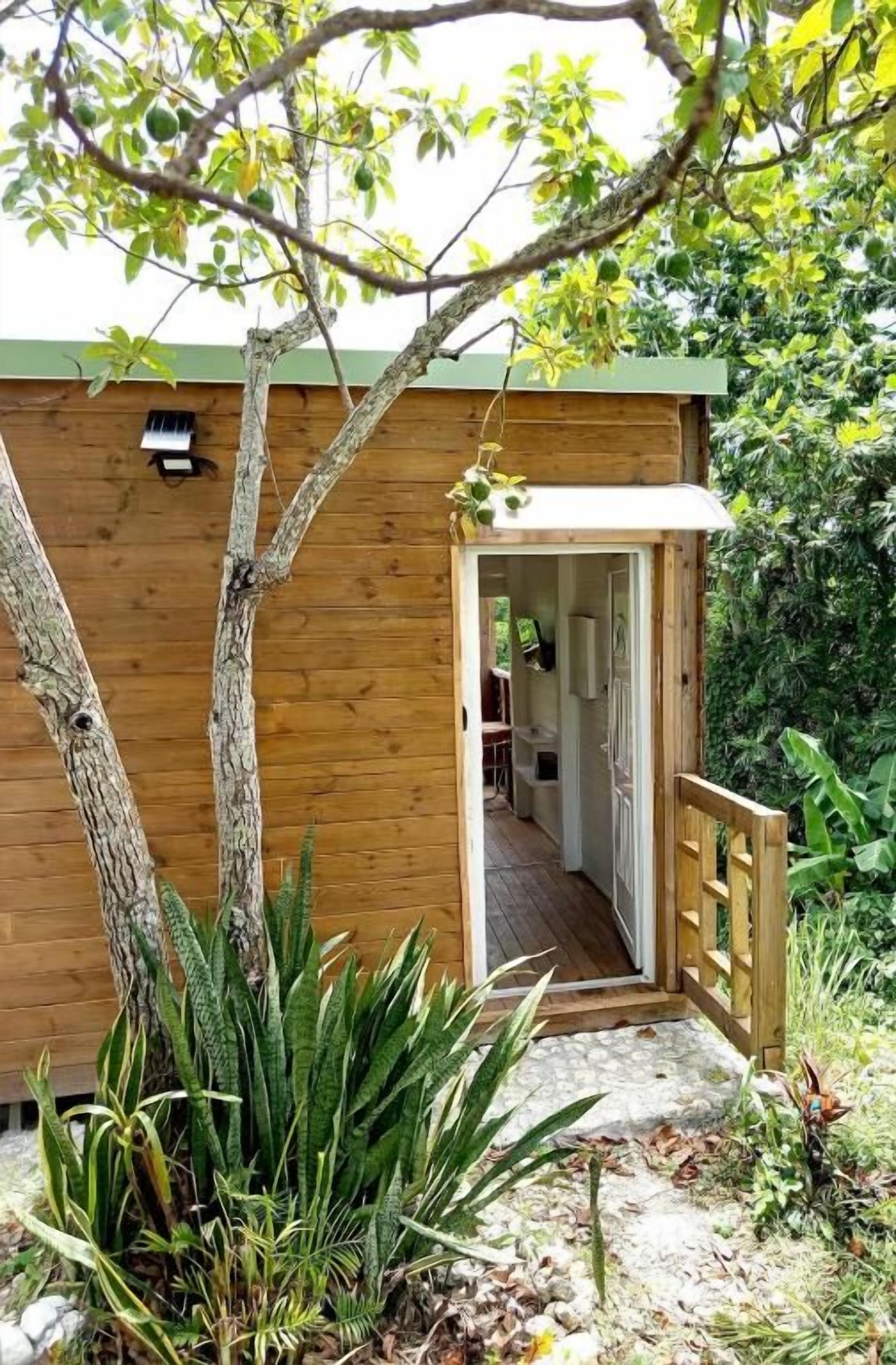 Uma cabana de madeira com uma porta que dá para o interior.