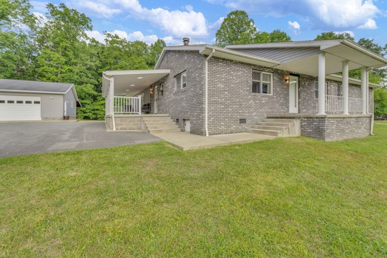 A two-story house with a covered porch, a garage, and a well-maintained lawn.