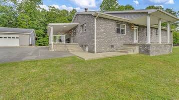 A two-story house with a covered porch, a garage, and a well-maintained lawn.